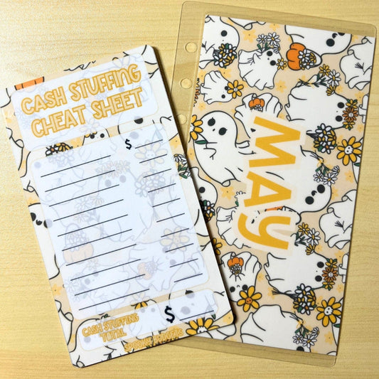 May include: A cash stuffing cheat sheet with a yellow and white ghost theme. The cheat sheet has a list of categories and a space to write the amount of money for each category. The sheet has the text &#39;CASH STUFFING CHEAT SHEET&#39; and &#39;CASH STUFFING TOTAL&#39;. A yellow and white ghost themed monthly calendar with the word &#39;MAY&#39; in yellow text.