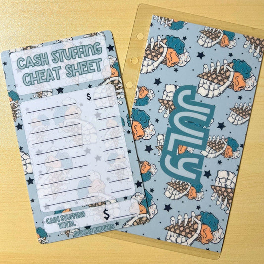 May include: A cash stuffing cheat sheet with a blue and white patterned background. The cheat sheet has a section for writing the amount of cash received and the total amount of cash received. The cheat sheet also has a section for writing the date. The text on the cheat sheet reads &#39;Cash Stuffing Cheat Sheet&#39;. The background pattern includes stars and the word &#39;July&#39;.